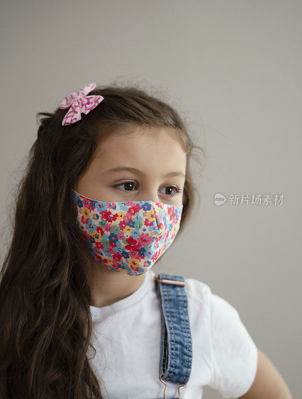 Portrait of 8 year old cute girl wearing homemade protective mask during quarantine